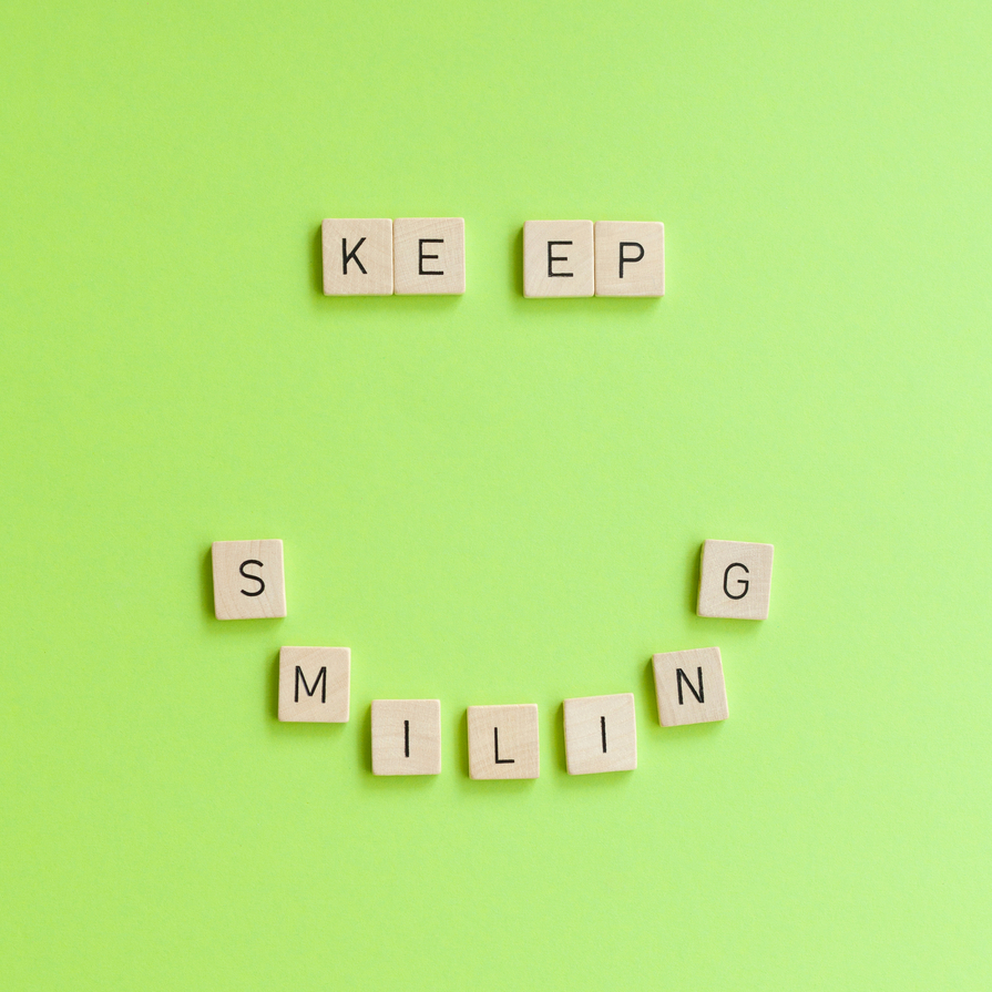 Wortplaettchen zu einem Lächeln angeordnet-Keep Smiling